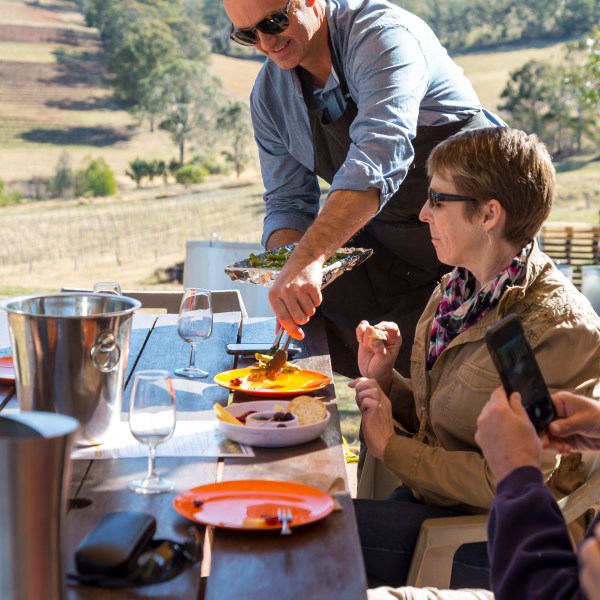 a man sitting at a table with a mountain in the background